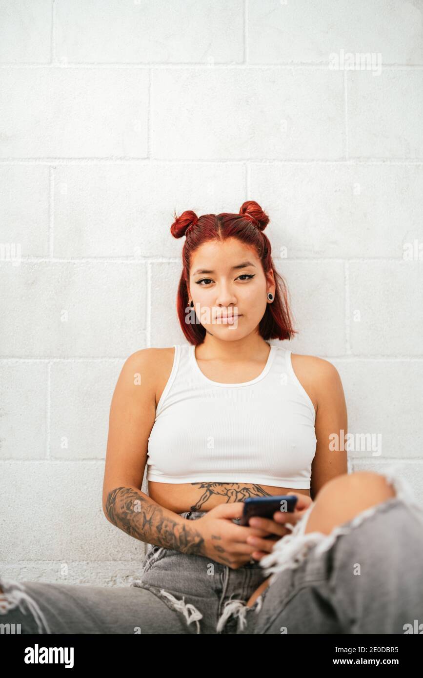 Moderne alternative ethnische weibliche Pause Tänzerin mit tätowierten Körper und Durchdringender Blick auf die Kamera Stockfoto