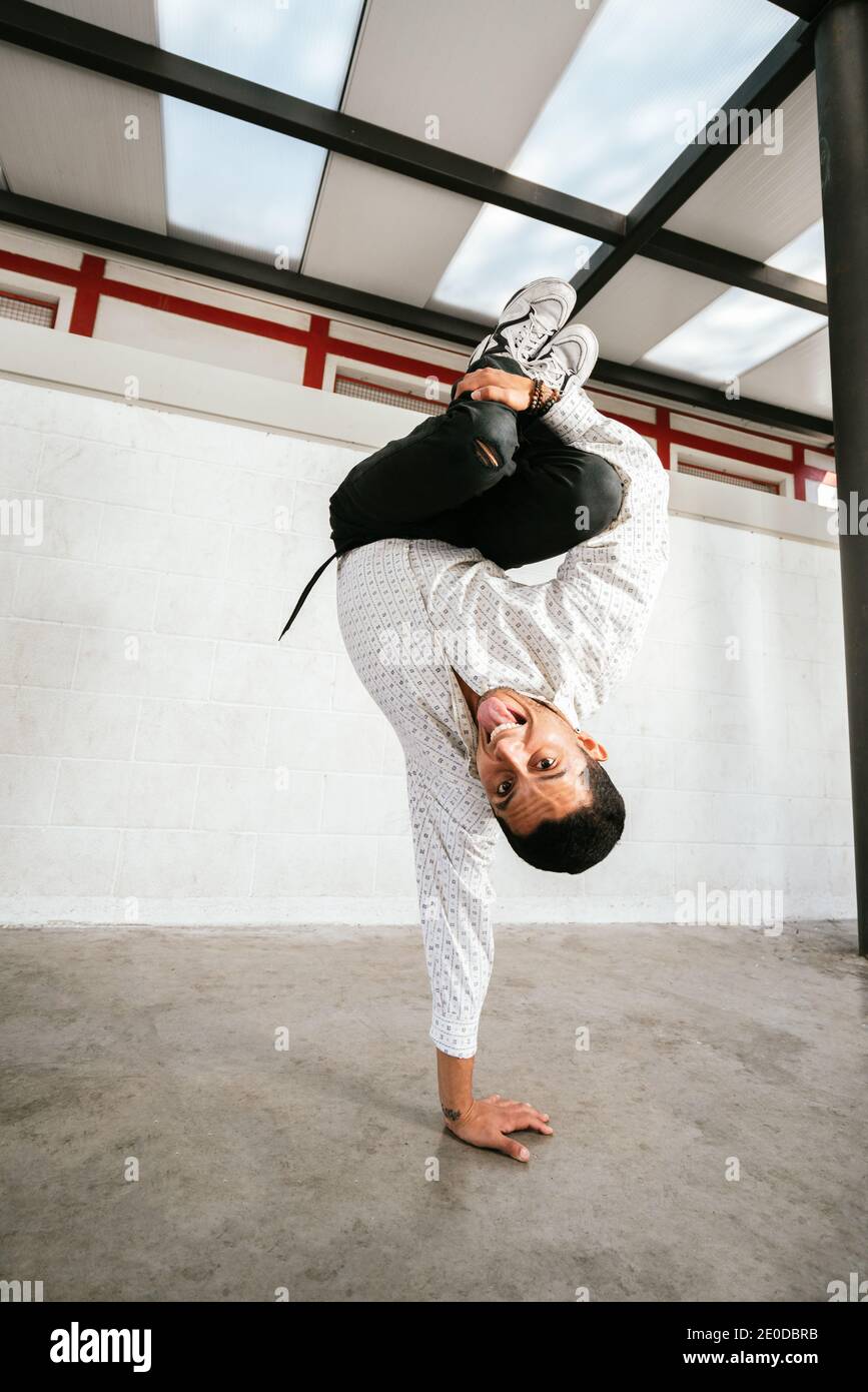 Voller Körper von energischen jungen Mann dabei akrobatische Handstand während Break Dance Stockfoto