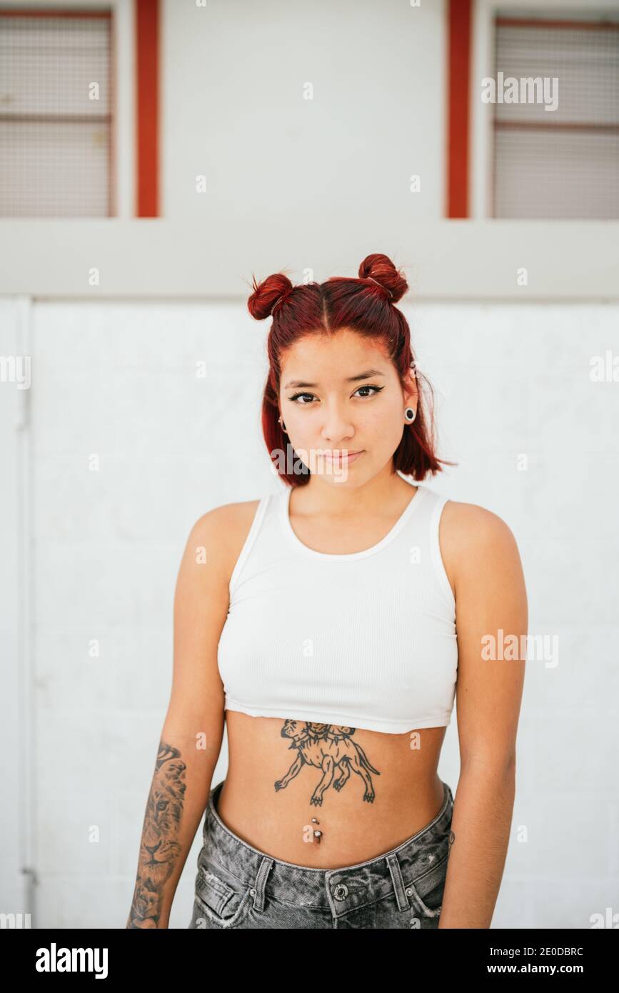Moderne alternative ethnische weibliche Pause Tänzerin mit tätowierten Körper und Durchdringender Blick auf die Kamera Stockfoto