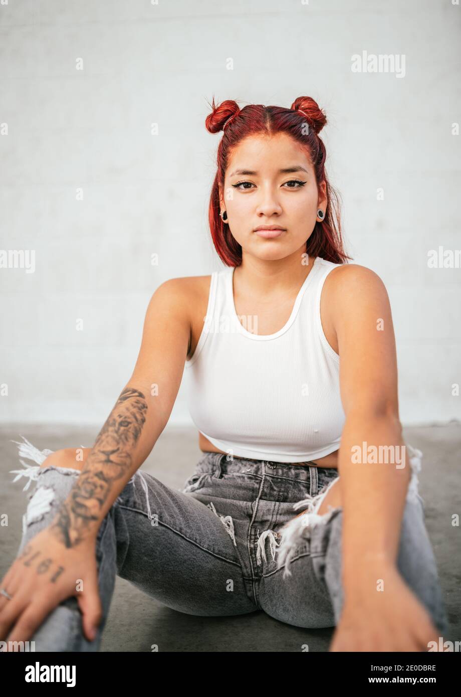 Moderne alternative ethnische weibliche Pause Tänzerin mit tätowierten Körper und Durchdringender Blick auf die Kamera Stockfoto