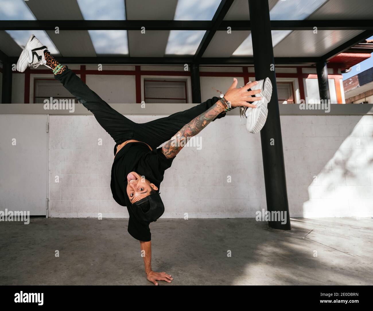 Voller Körper von energischen jungen Mann dabei akrobatische Handstand während Break Dance Stockfoto