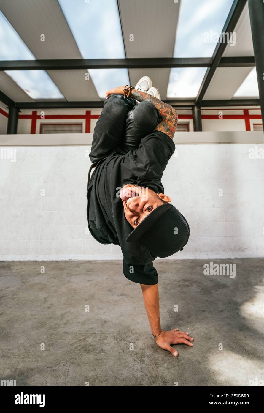 Voller Körper von energischen jungen Mann dabei akrobatische Handstand während Break Dance Stockfoto