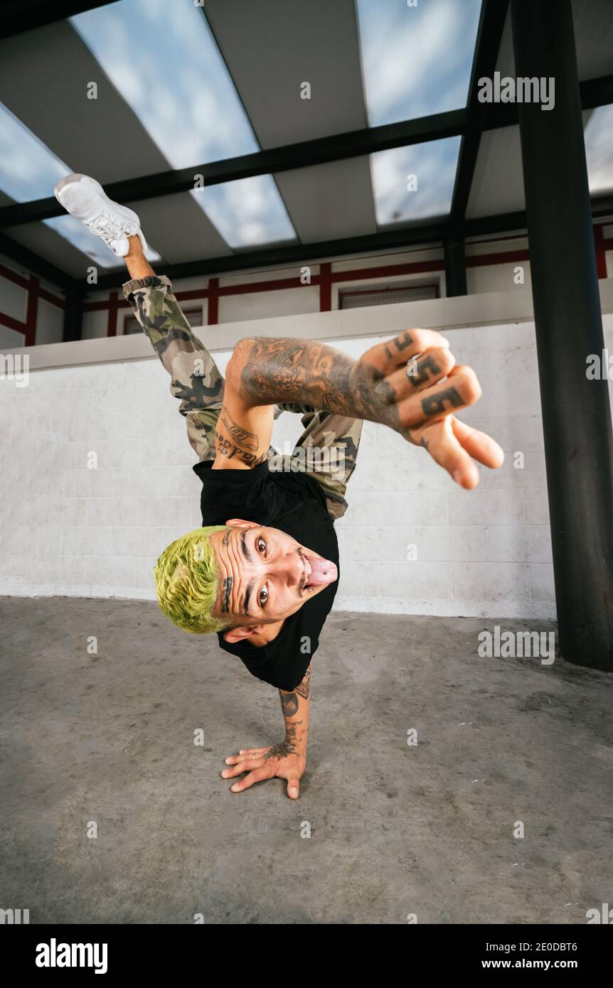 Voller Körper von energischen jungen Mann dabei akrobatische Handstand während Break Dance Stockfoto