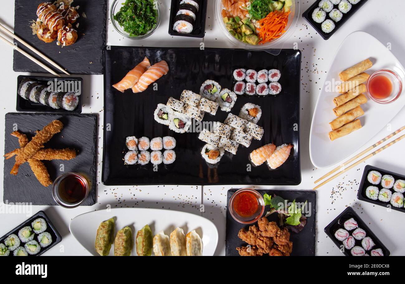 Von oben aus verschiedene Sushi und Brötchen auf den Tisch gelegt Im asiatischen Restaurant Stockfoto