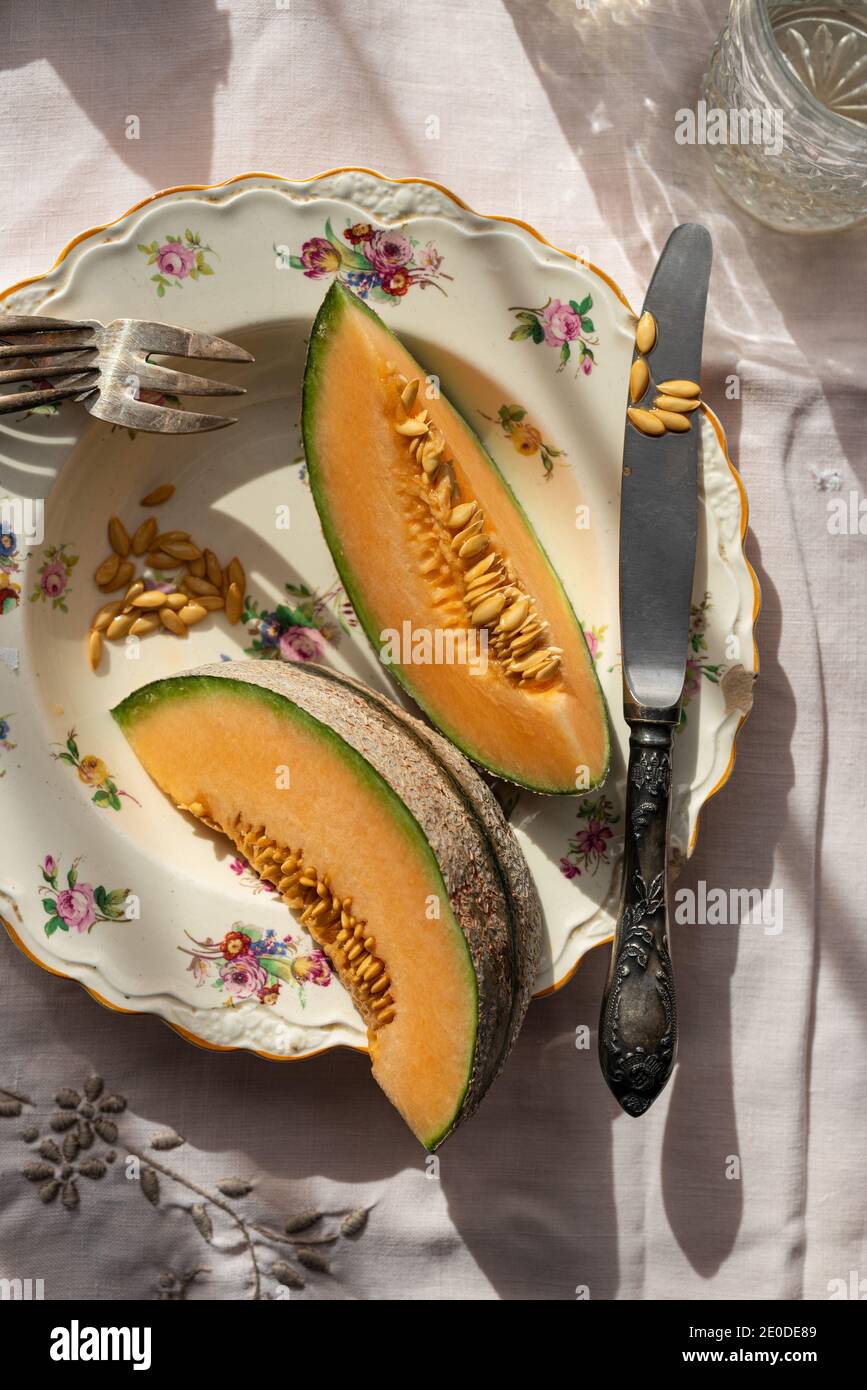 Blick von oben auf Scheiben von süßer Melone auf dem Teller serviert Auf dem Tisch in der Landschaft an sonnigen Tag Stockfoto