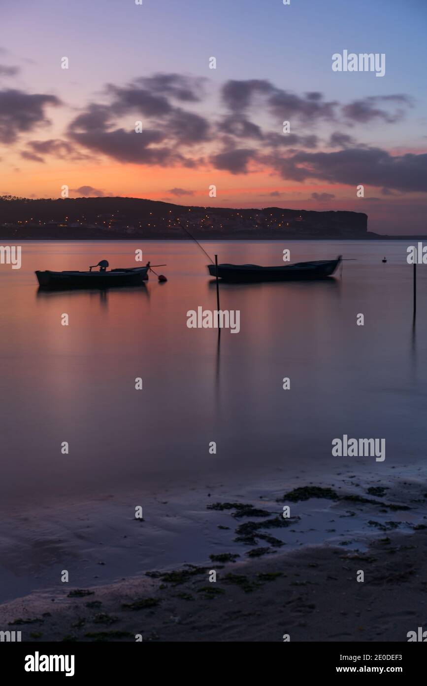 Fischerboote auf einem Flussmeer bei Sonnenuntergang in Foz do Arelho, Portugal Stockfoto