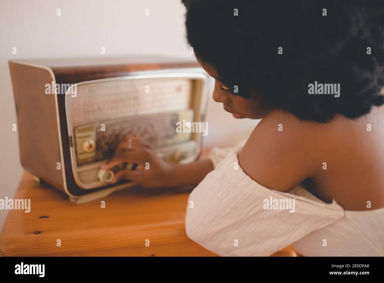 Fröhliche kolumbianische junge Dame trägt trendige Denim-Kleidung und Schutzhelm stehen mit Fahrrad in der Nähe von modernen Glasgebäude während des aktiven Hobby pra Stockfoto