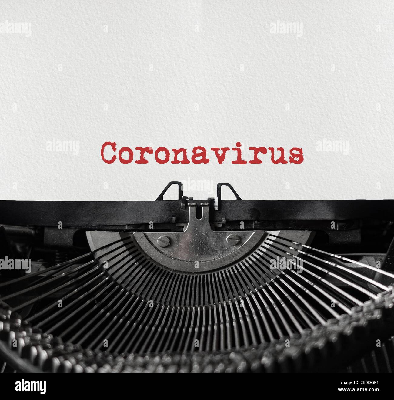 Mechanische Schreibmaschine in der Mitte mit einem weißen Blatt Papier. Metallische Maschine mit geschriebendem Text Coronavirus. Pandemiekonzept. Coronavirus Stockfoto