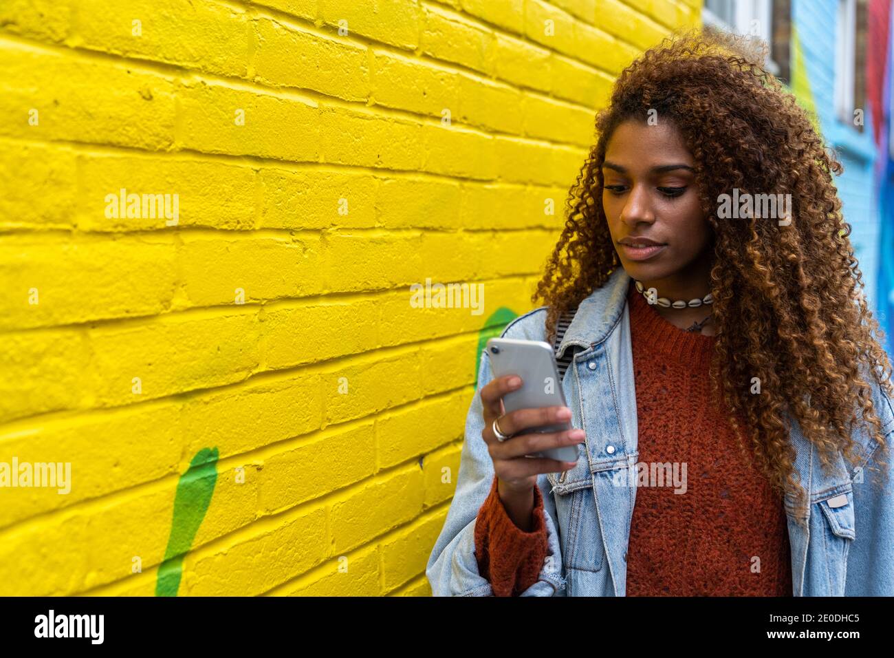 Reflexion der nachdenklichen ethnischen weiblich in lässigen Outfit mit lang Haare und helle Lippen im Spiegel Stockfoto