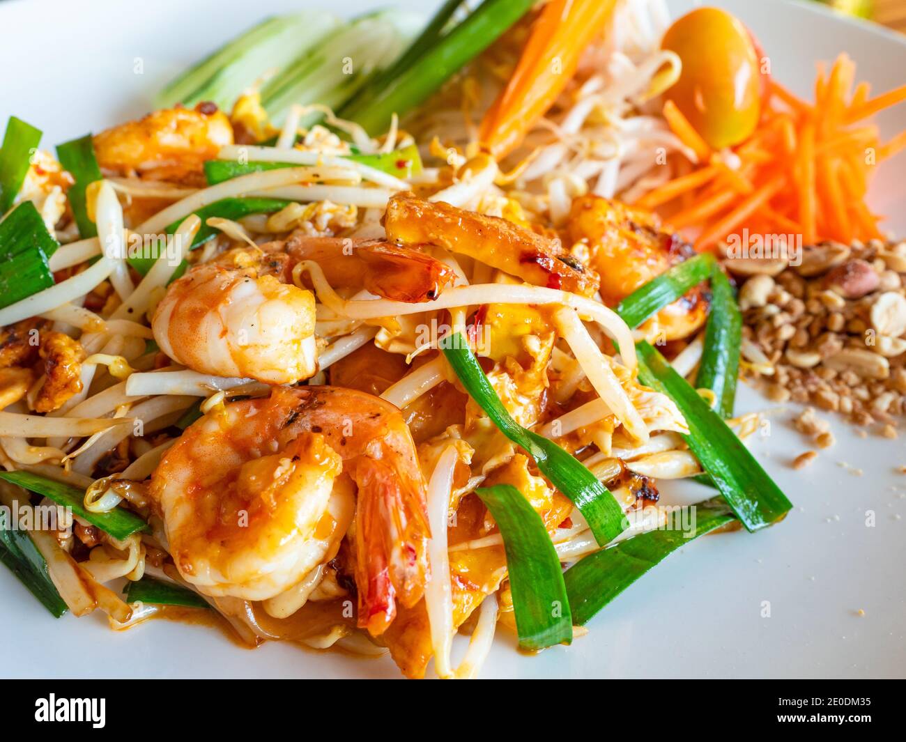 Das klassische Thai Dish Pad Thai, bestehend aus gebratenen Nudeln mit Garnelen, Bohnensprossen, gebratenem Tofu, zerkleinerten Erdnüssen und Frühlingszwiebeln, mit Gurke und Stockfoto