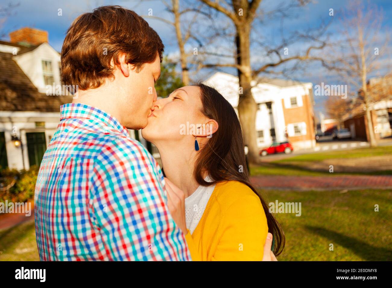 Junge glückliche Paar Kuss schließen Portrait Stand im öffentlichen Park Profilansicht Stockfoto