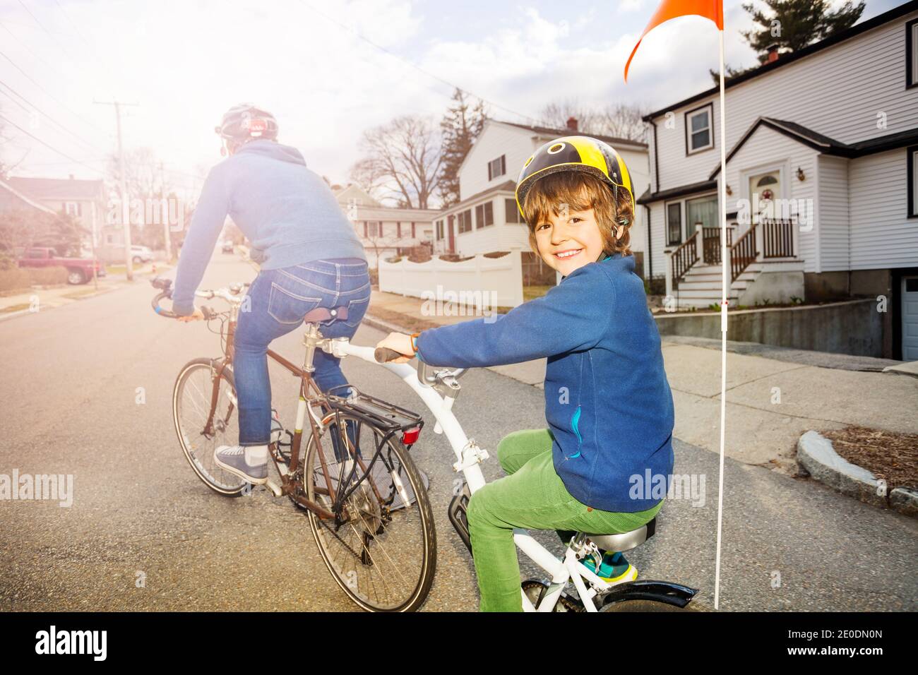 Porträt eines kleinen Jungen auf einem Tow Tandem fahren Fahrrad am Vater auf der städtischen Straße Blick von hinten befestigt Stockfoto