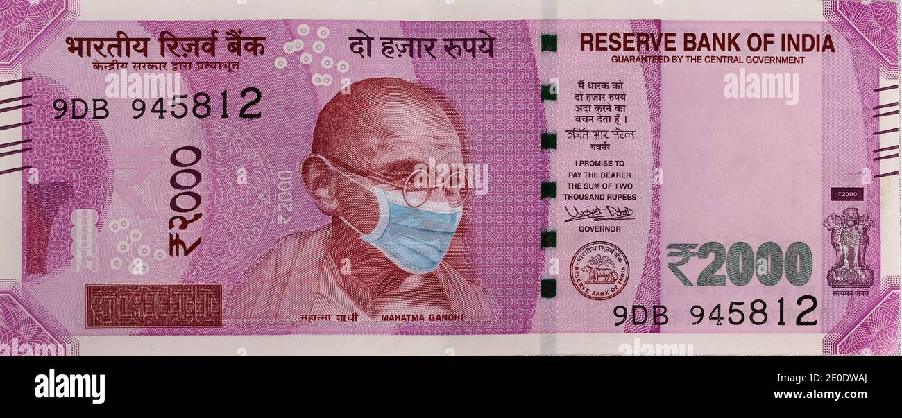 COVID-19 Coronavirus in Indien. Zweitausend Indische Rupie, Rs. 2020 Banknote mit Mahatma Gandhi mit Covid-19 Maske. Stockfoto