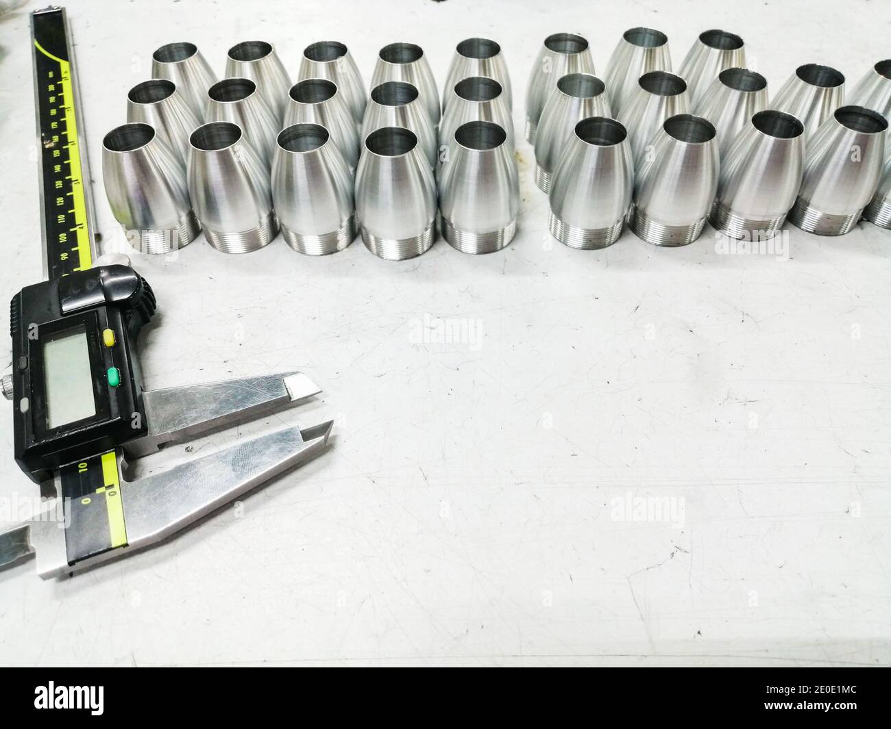 messschieber und einige Aluminiumteile auf einem weißen Tisch Stockfoto