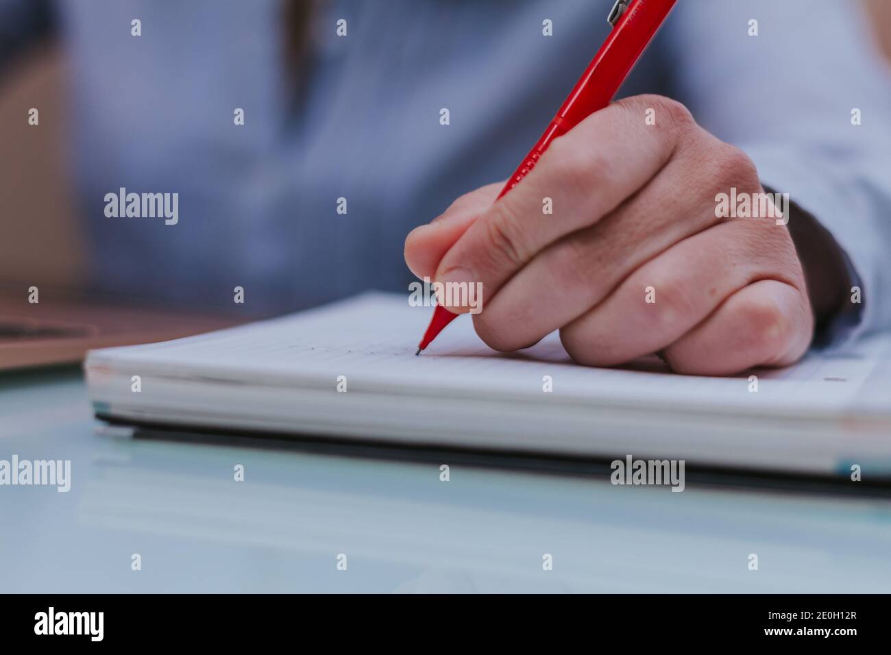 Weibliche Hände mit einem roten Stift schreiben auf Notebook. Stockfoto
