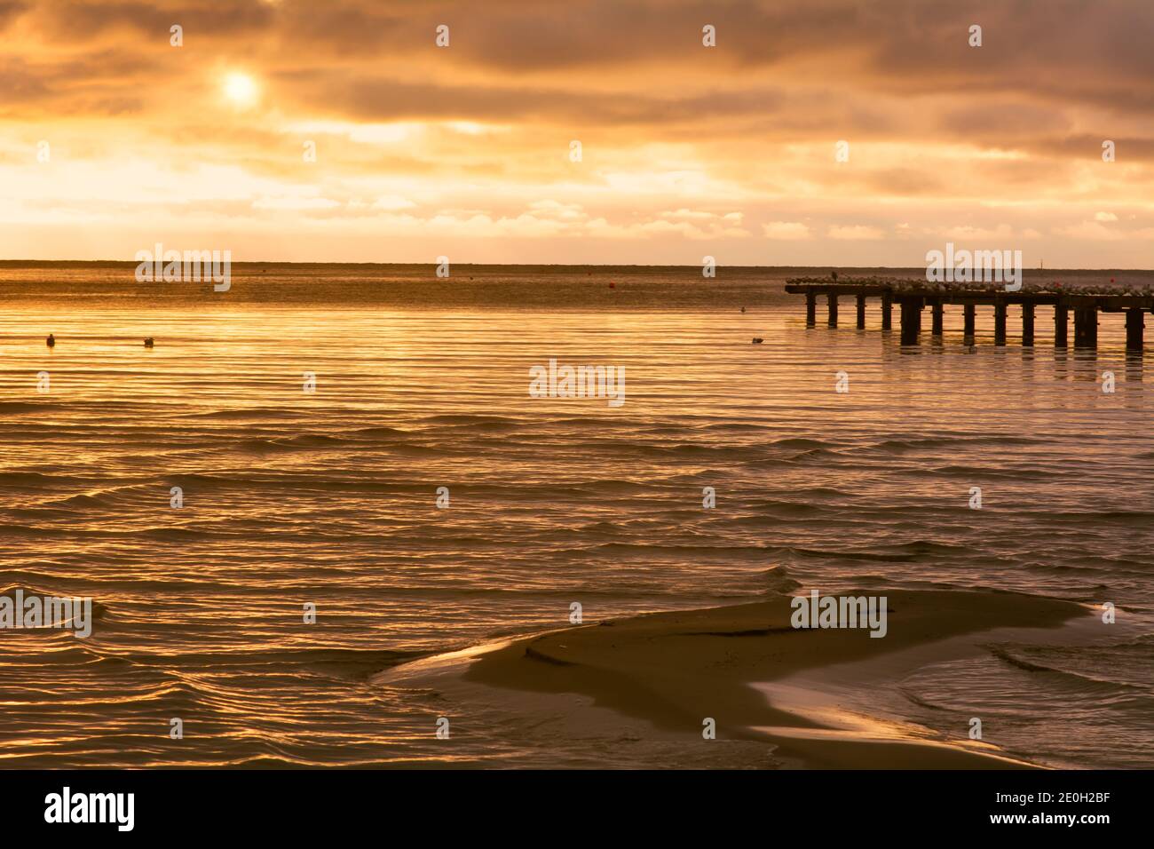 Eine Sandbar mit einem wunderschönen Sonnenuntergang am Meer im Hintergrund. Foto aus Hallevik, Blekinge County, Schweden Stockfoto