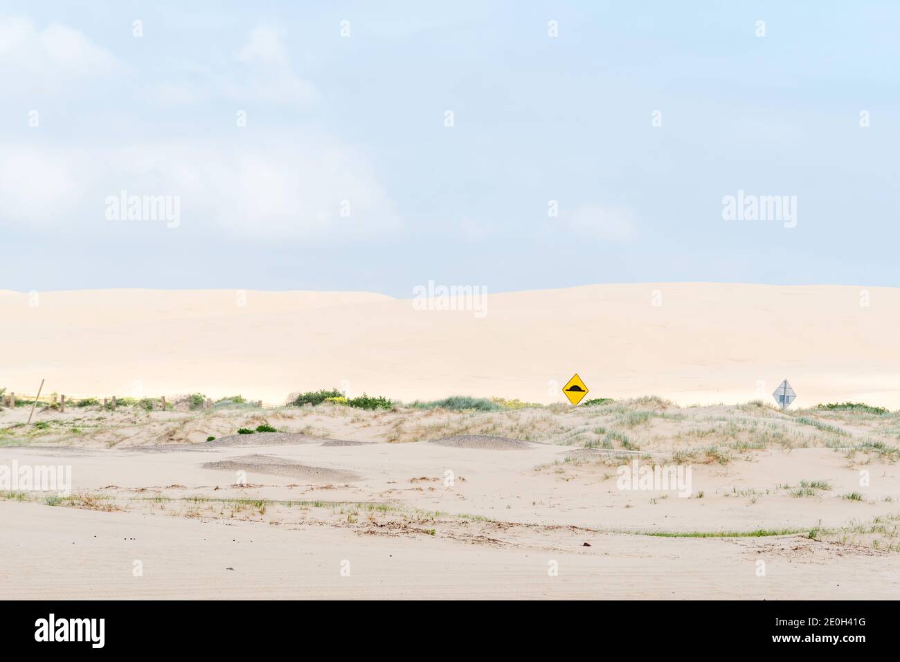 Straßenschilder sind fast unter sich verschiebenden Sanddünen am Birubi Beach in der Nähe von Anna Bay und Nelson Bay in Port Stephens, NSW, Australien, vergraben Stockfoto