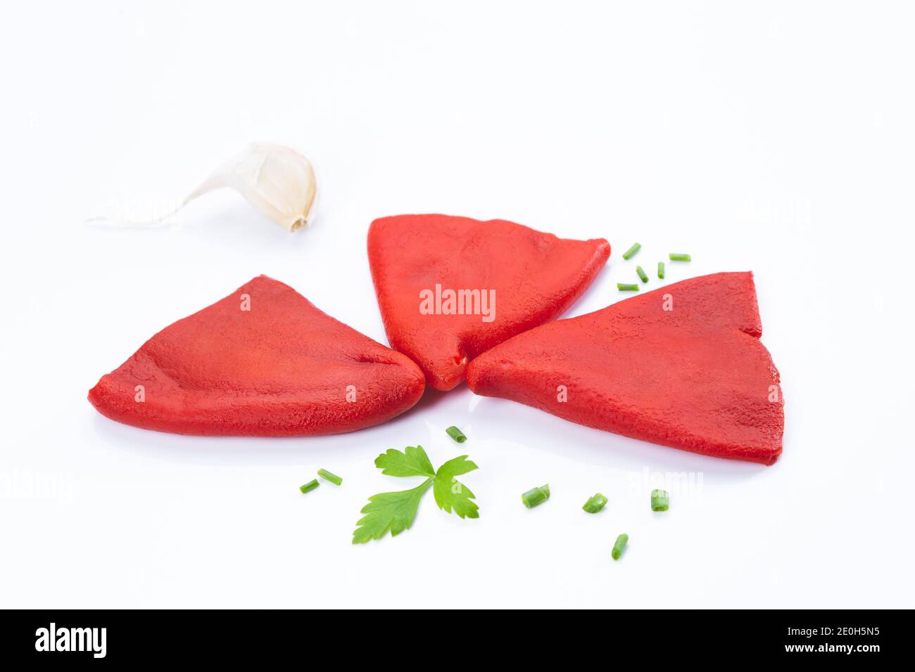 Geröstete Paprika mit Knoblauch, Petersilie und Schnittlauch auf weißem Hintergrund isoliert. Stockfoto