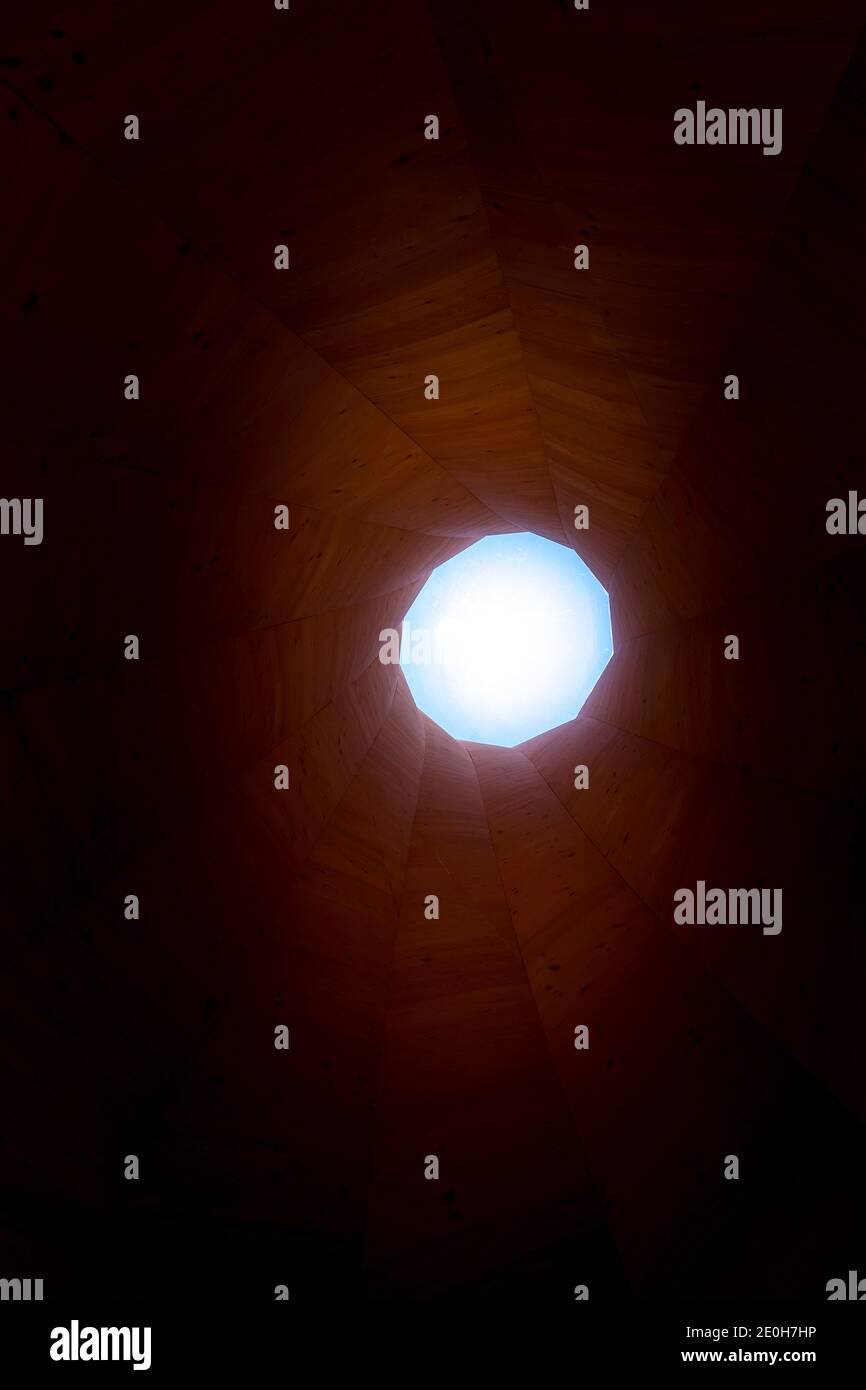 Turm oder Tunnel aus Holz mit Holzkonstruktionen oder Licht am Ende des Tunnels Stockfoto
