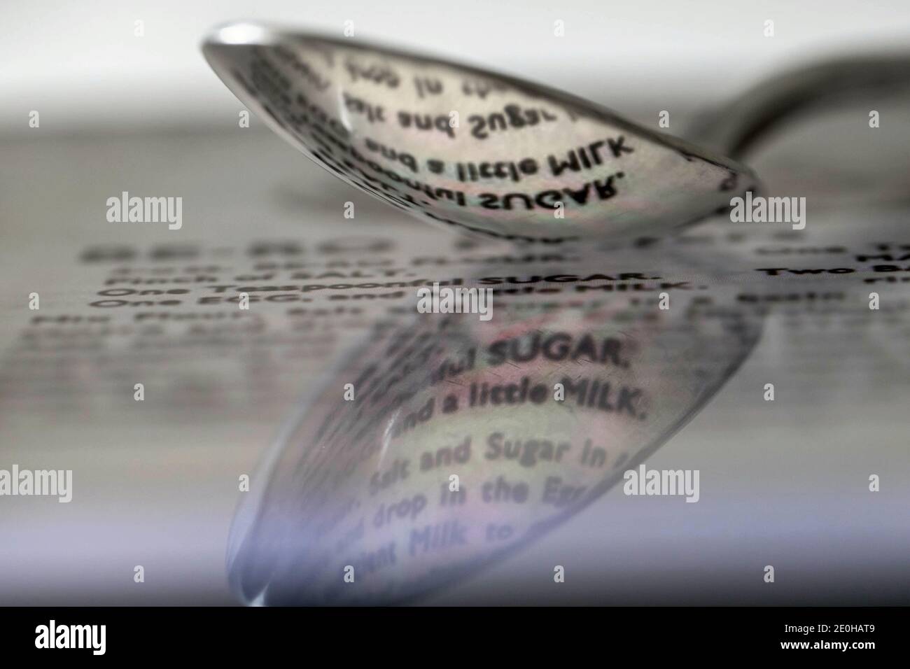 Löffel reflektiert Wörter aus einem Rezept Stockfoto