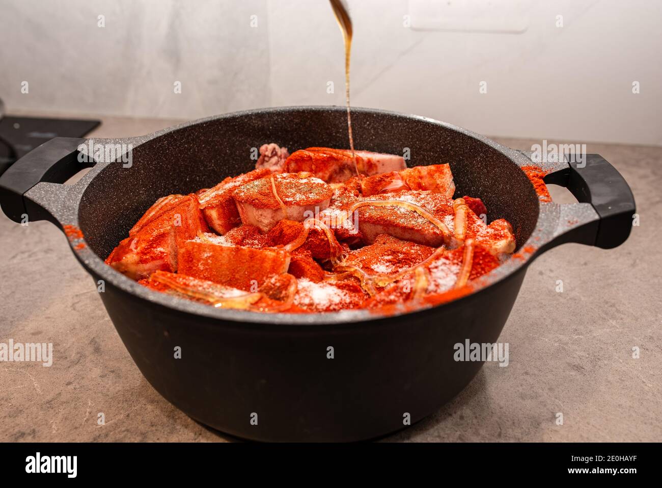 Frau, die Lebensmittel zubereitet, gieße Honig oder Sauce auf die Mahlzeit. Stockfoto