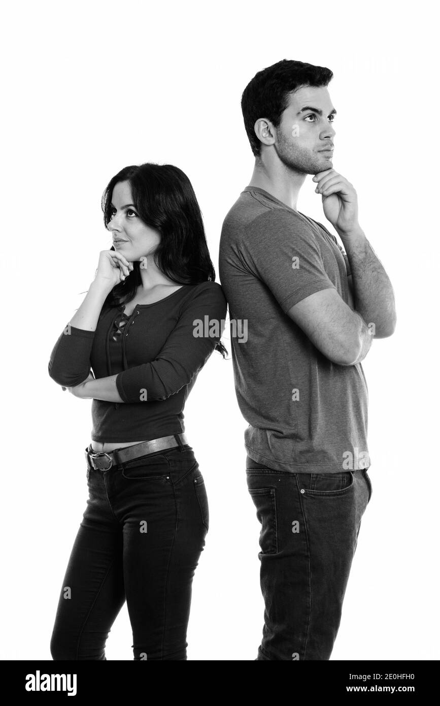 Studio Aufnahme des jungen Paares steht beim Denken und zusammen mit Rücken an Rücken Stockfoto