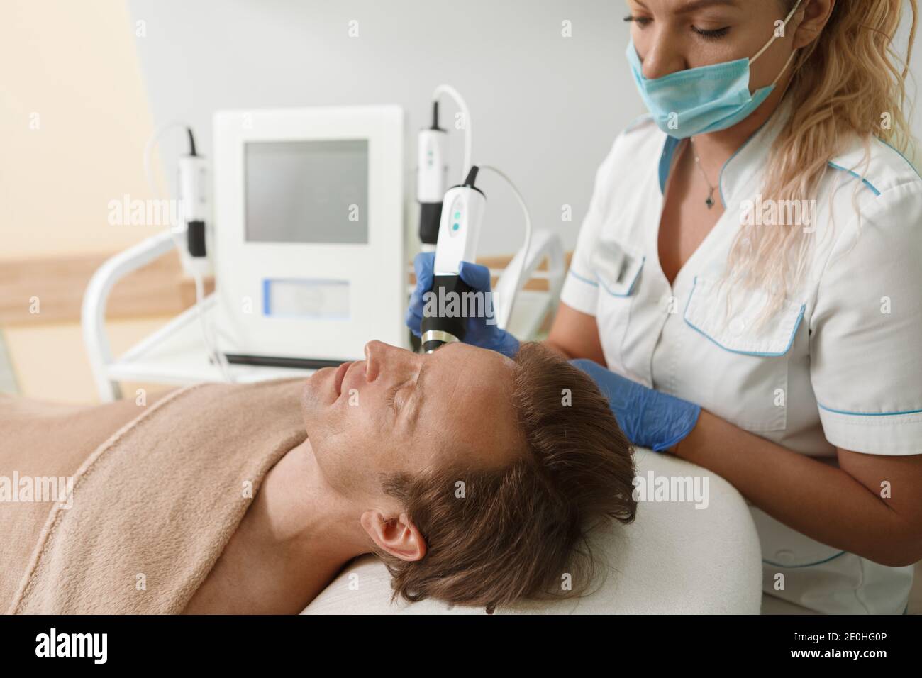 Zugeschnittene Aufnahme einer Kosmetikerin in der medizinischen Gesichtsmaske arbeiten Während einer Coronavirus-Pandemie Stockfoto