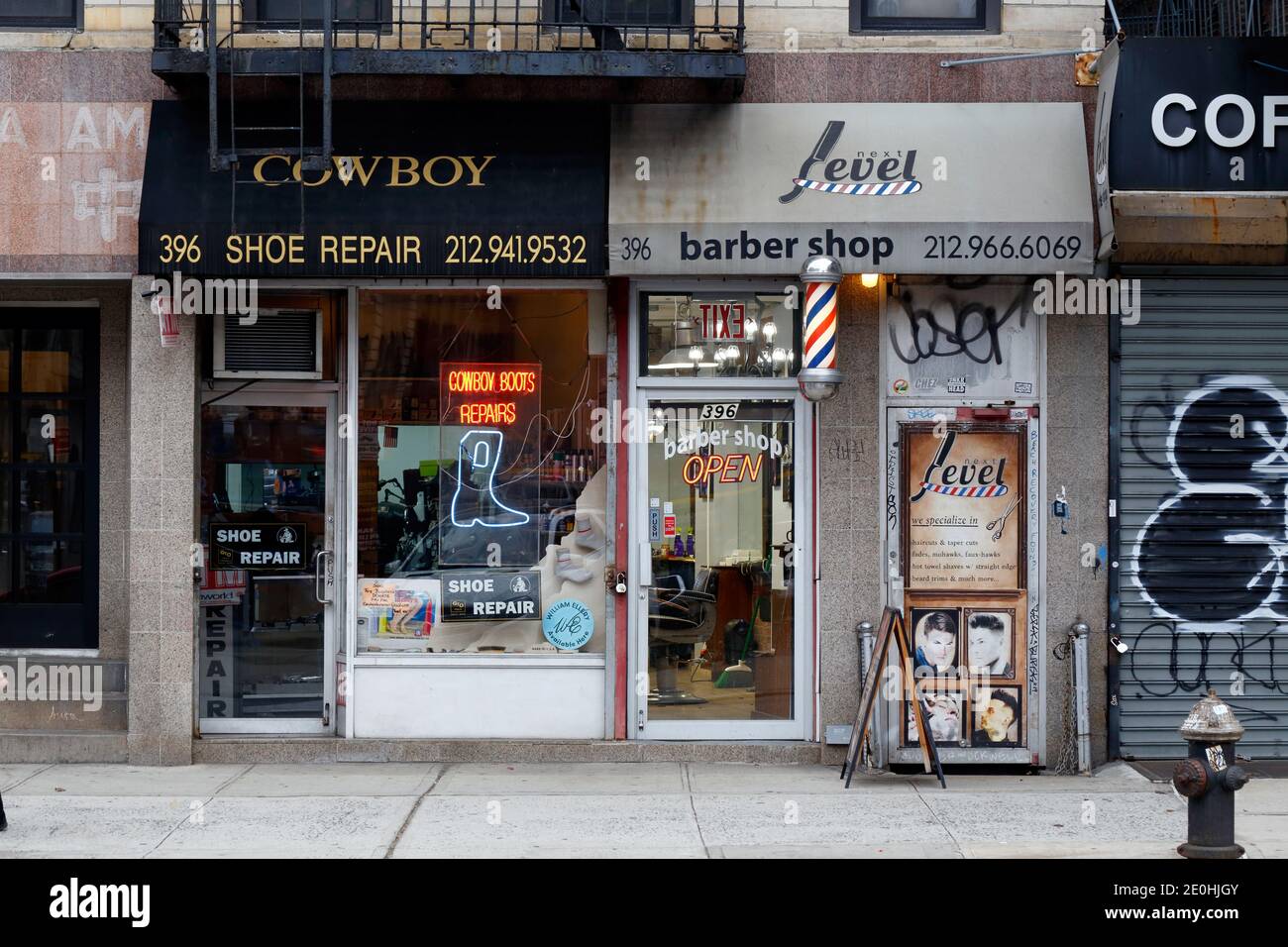Cowboy Shoe Repair, Next Level Barber Shop, 396 Broome St, New York, NY. Außenfassade eines Schuhreparaturladens und eines Friseurladens in SoHo. Stockfoto