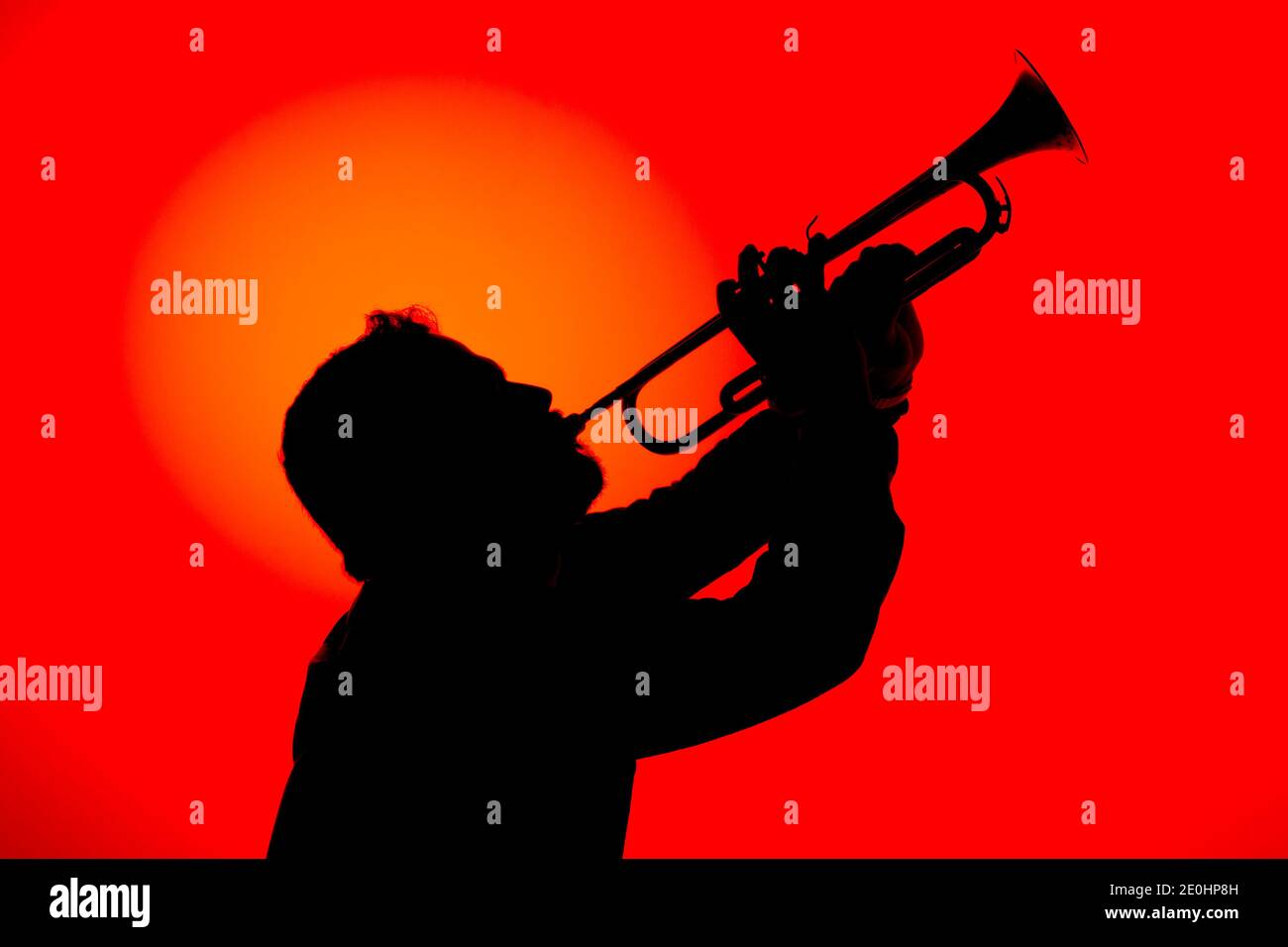 Silhouette eines Jazzmusikers, der Trompete spielt, isoliert auf rotem Hintergrund. Jazz-Musik-Konzept. Stockfoto
