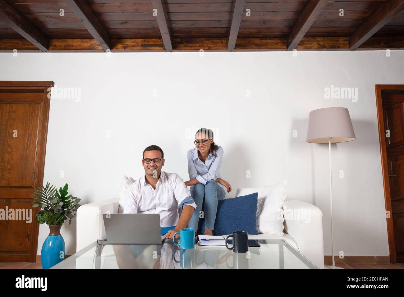 Junge Erwachsene Paar Blick auf den Laptop im Wohnzimmer zu Hause. Stockfoto