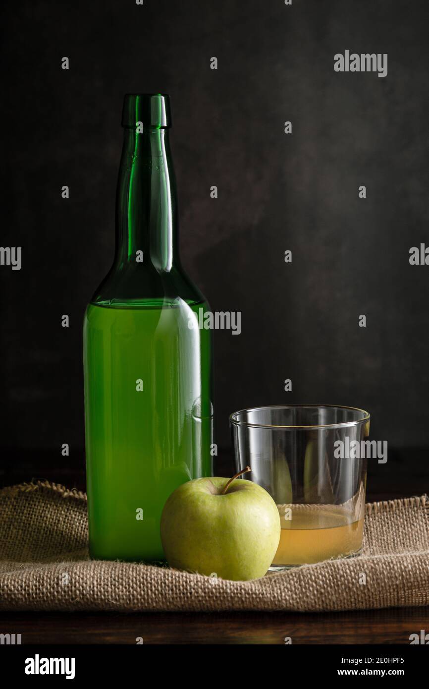 Flasche asturischen Apfelwein mit Glas und Apfel auf dunklem Hintergrund. Stockfoto