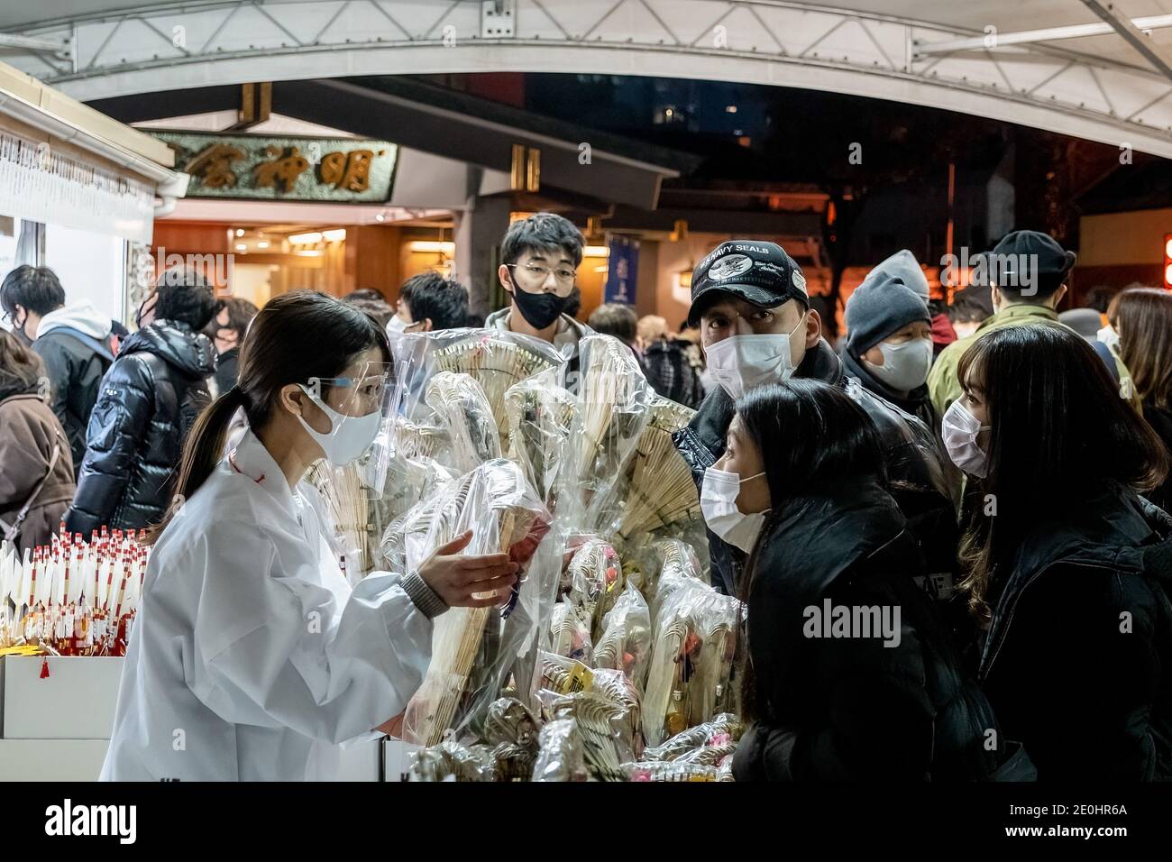 Tokio, Japan. Januar 2021. Menschen mit Masken als vorbeugende Maßnahme gegen die Verbreitung von covid-19 kaufen Omamori bei ihrem Besuch im Shinmei-Schrein. Da die Covid-19-Coronavirus-Infektionen andauern, haben die japanischen Behörden die Menschen aufgefordert, sich nicht in großer Zahl zu versammeln, während sie das neue Jahr feiern. Kredit: SOPA Images Limited/Alamy Live Nachrichten Stockfoto