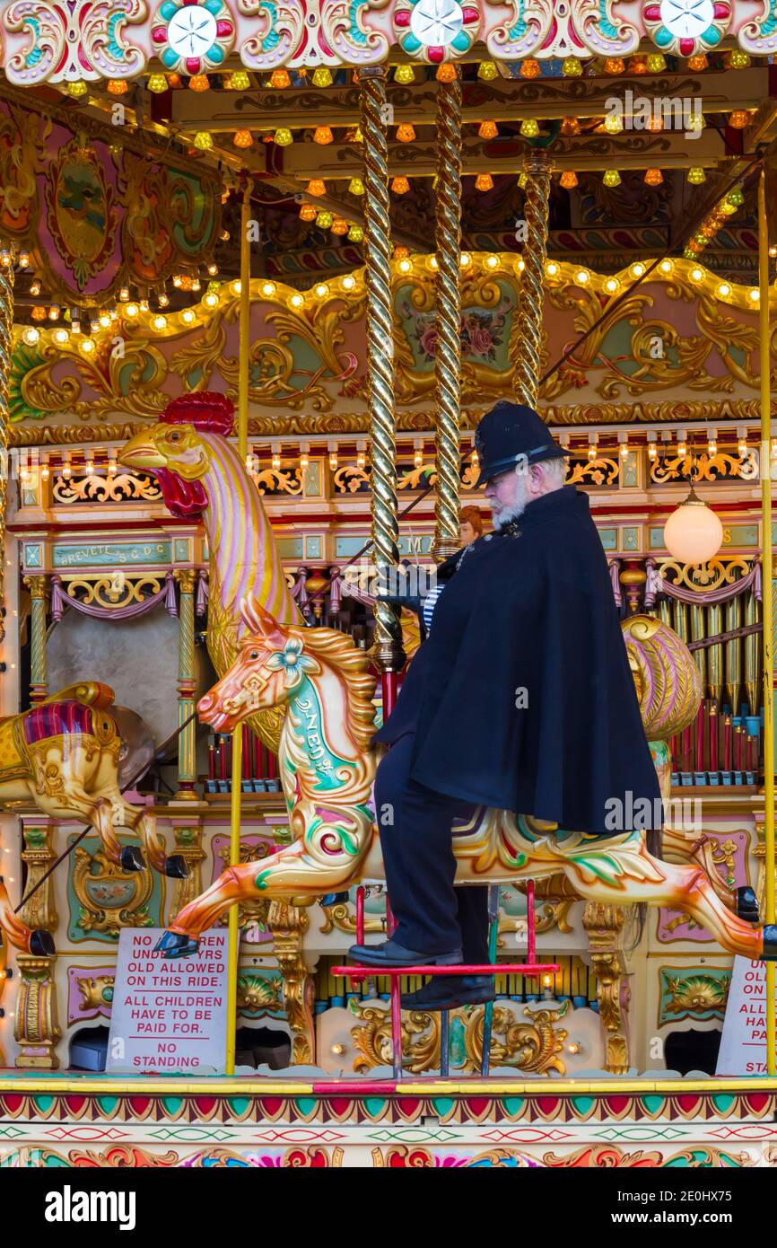 Viktorianischer Polizist, der auf dem Karussell reitet, beim Victorian Festival of Christmas in Portsmouth, Hants England im Dezember Stockfoto