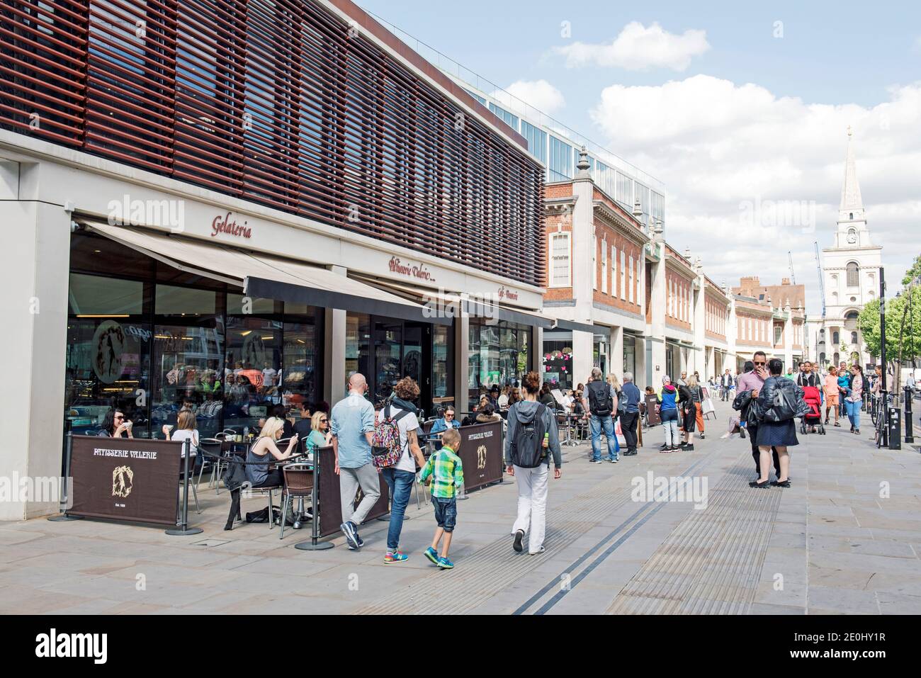 Belebte Straßenszene mit Leuten, die außerhalb der Patisserie sitzen und essen Valerie in Fußgängerzone Brushfield Street Christ Church in der Ferne Spitalfield Stockfoto