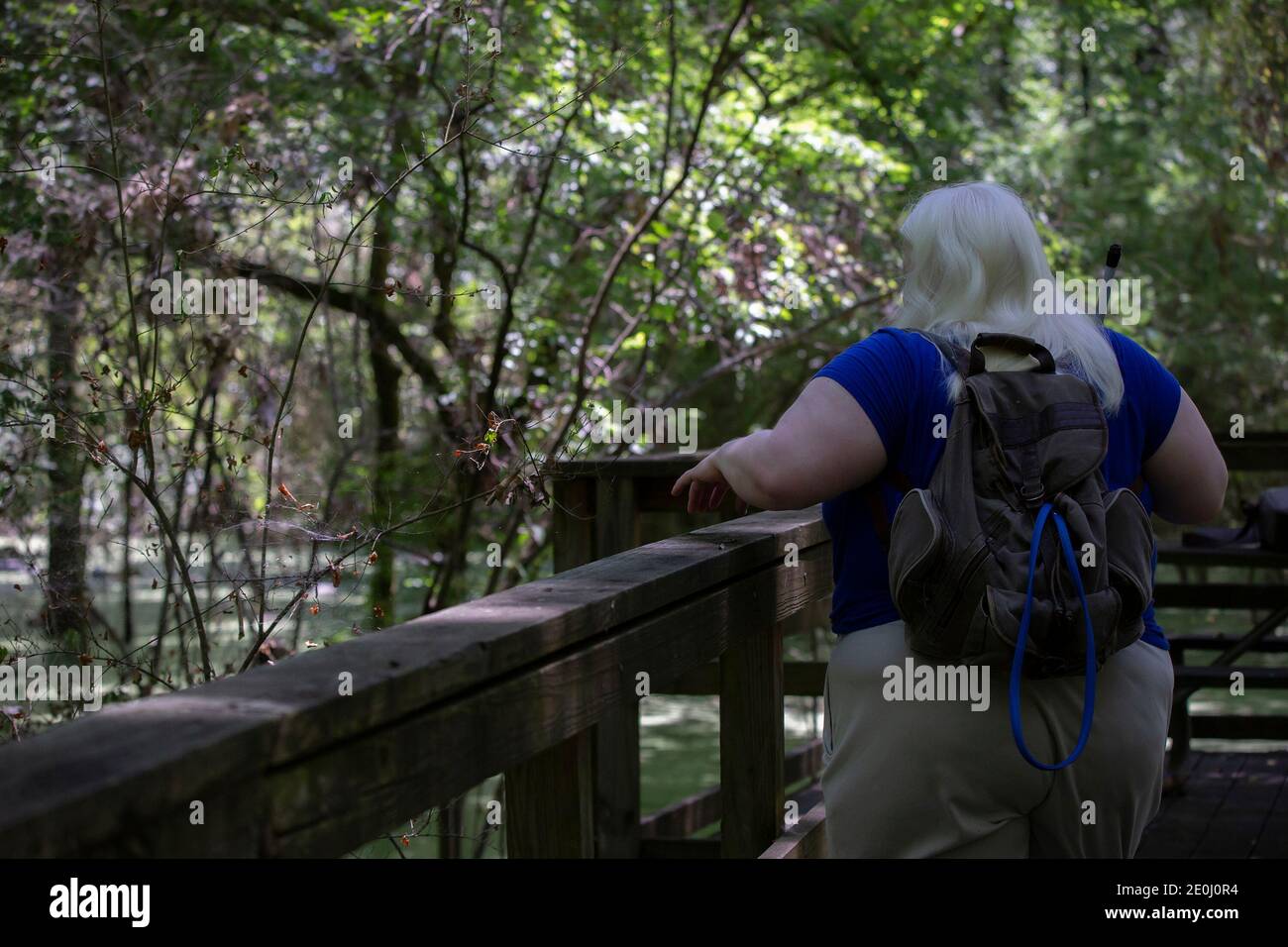 Als blind albino Frau über Geländer zu einem Sumpf suchen Stockfoto