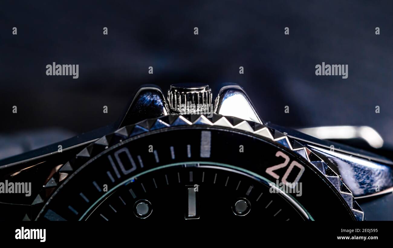 Nahaufnahme der Krone einer schwarzen und verchromten Herrenarmbanduhr. Stockfoto