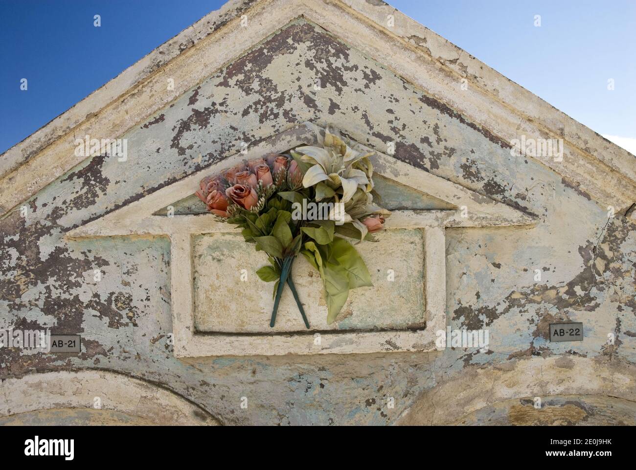 Blumen schmücken Krypten auf dem Friedhof neben der historischen und bunten St. Anna's Catholic Church, Noord, Aruba. Stockfoto