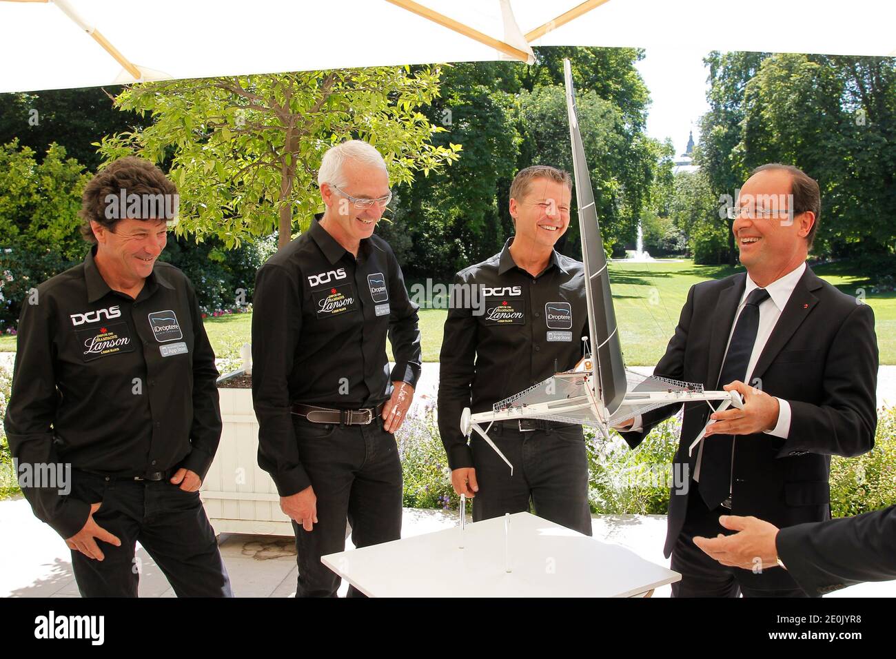 Frankreichs Präsident Francois Hollande (R) hält ein maßstabsgetreuer Modell des Hydroptere, ein Handwerk, das mit Folien entworfen ist, um über die Oberfläche des Wassers zu steigen, wie Skipper Jean Le Cam (L), Yves Parlier (2ndl), Und Alain Thebault (2ndR) reagiert am 23. Juli 2012 in den Gärten des Elysée-Palastes in Paris, Frankreich. Die Skipper werden versuchen, den bestehenden Weltrekord für die 6000 km zwischen Los Angeles und Honolulu im 24 Meter Trimaran zu brechen. Foto von John Schults/Pool/ABACAPRESS.COM Stockfoto