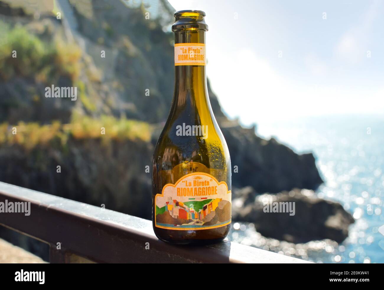 Blick von einer Terrasse mit Blick auf das Mittelmeer von einer Flasche La Bireta Riomaggiore, das lokale Bier des Dorfes Riomaggiore, Italien Stockfoto