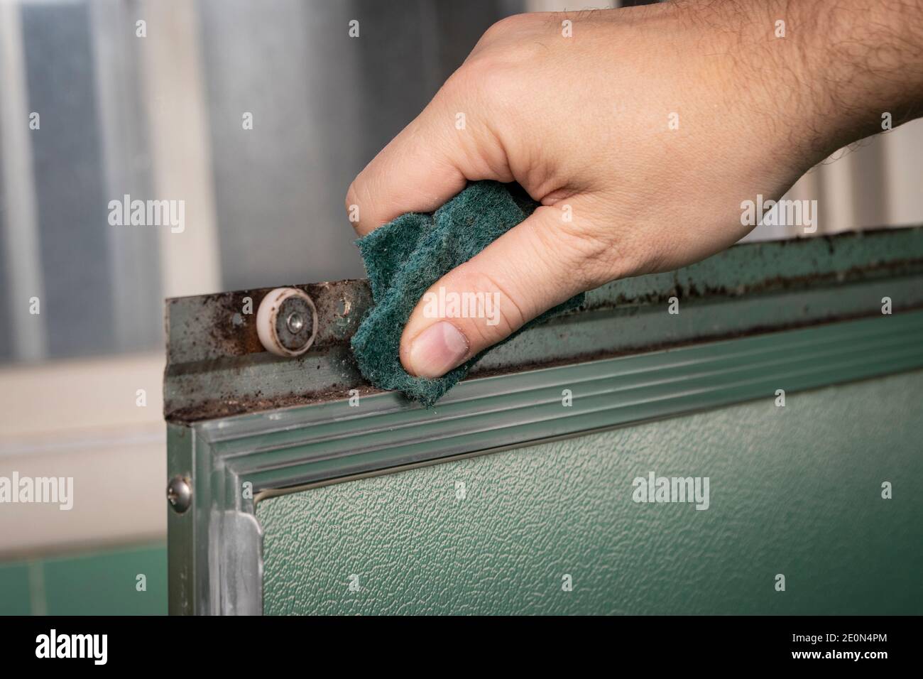 Handschrubben Schiebetür Rahmen mit grünen Scheuermatte, in Retro-farbigen und Stil Hause Bad Einstellung. Stockfoto