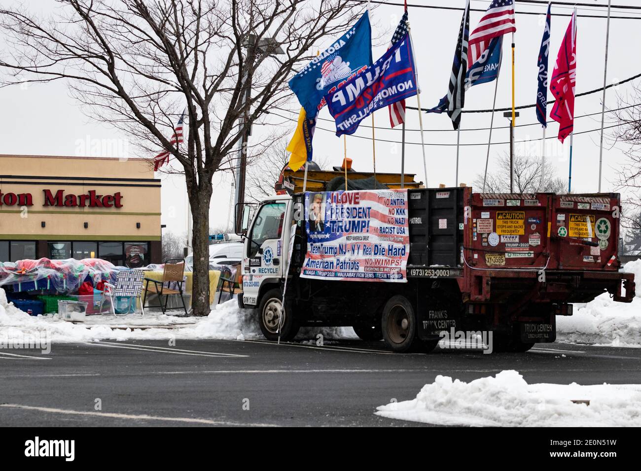 Lange nachdem Donald Trump die Wahl 2020 verloren hatte, schmückt ein Unterstützer seinen Lastwagen mit Pro-Trump- und Anti-Biden-Fahnen und Transparenten und sitzt am Straßenrand in t Stockfoto