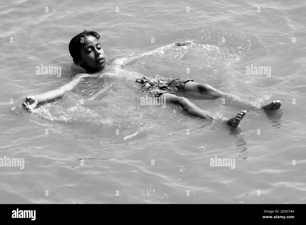 Ein Junge, der an einem heißen Sommertag in Essaouira an der Küste Marokkos im Atlantik schwimmt. Stockfoto