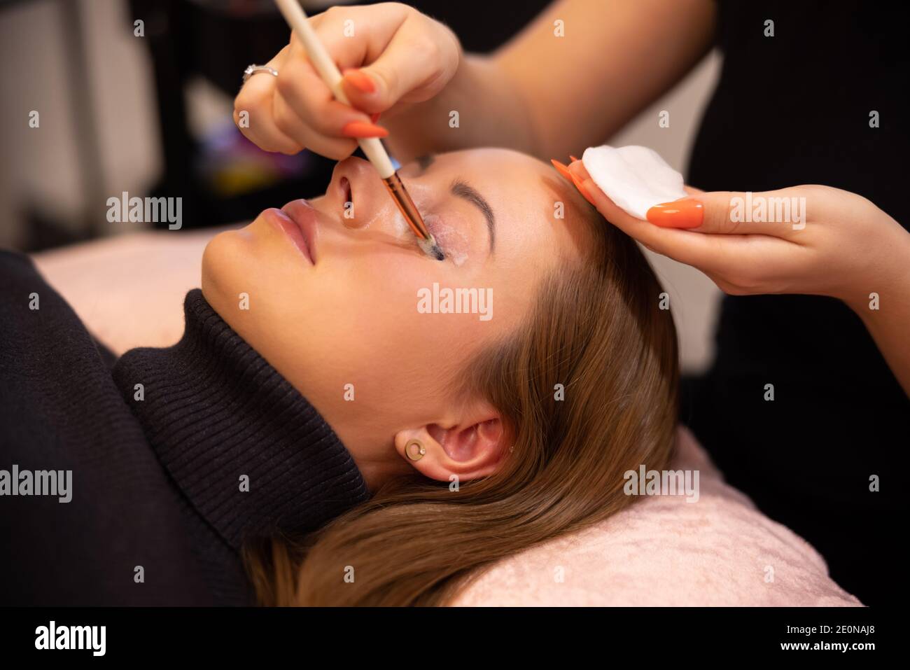 Hände des Kosmetologen Anwendung Creme auf weibliche Client Augenlid Stockfoto