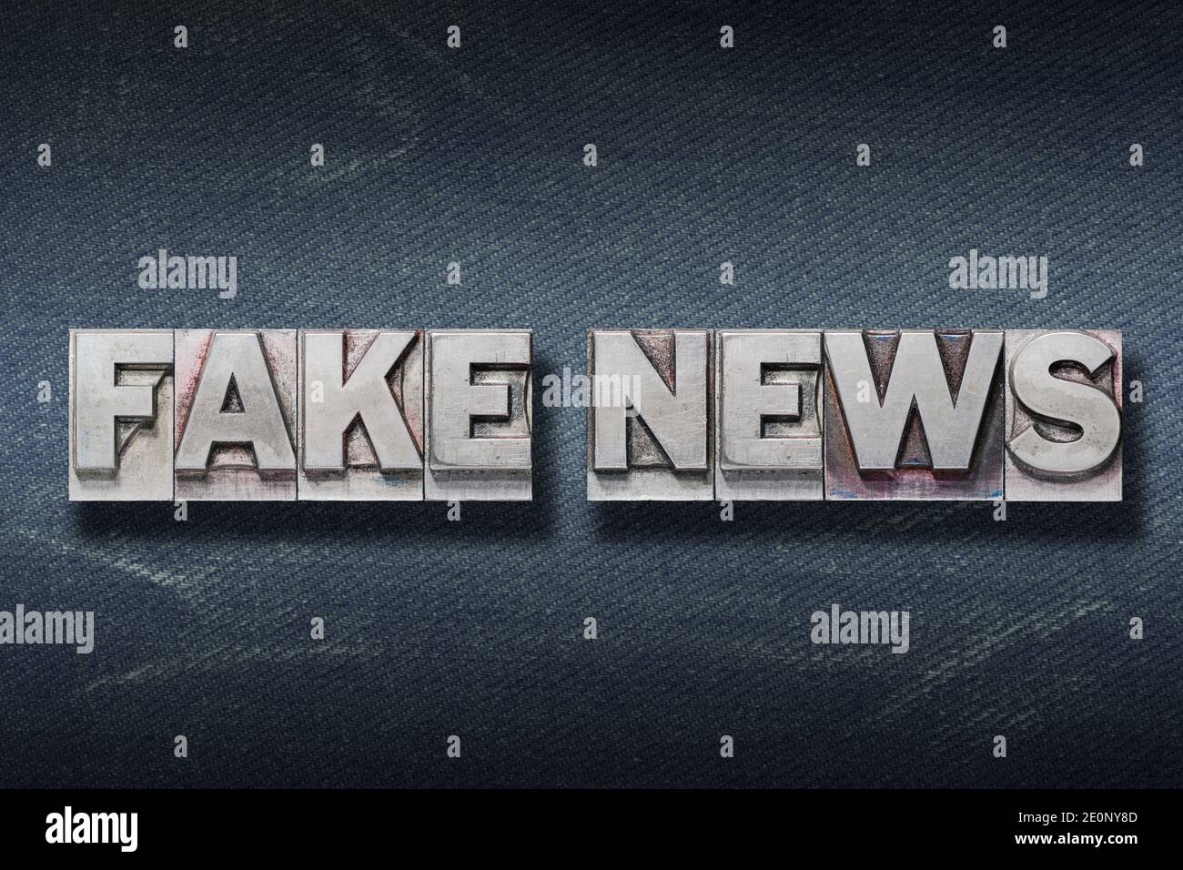 Fake News Phrase aus Metallic-Buchdruck auf dunklen Jeans Hintergrund Stockfoto