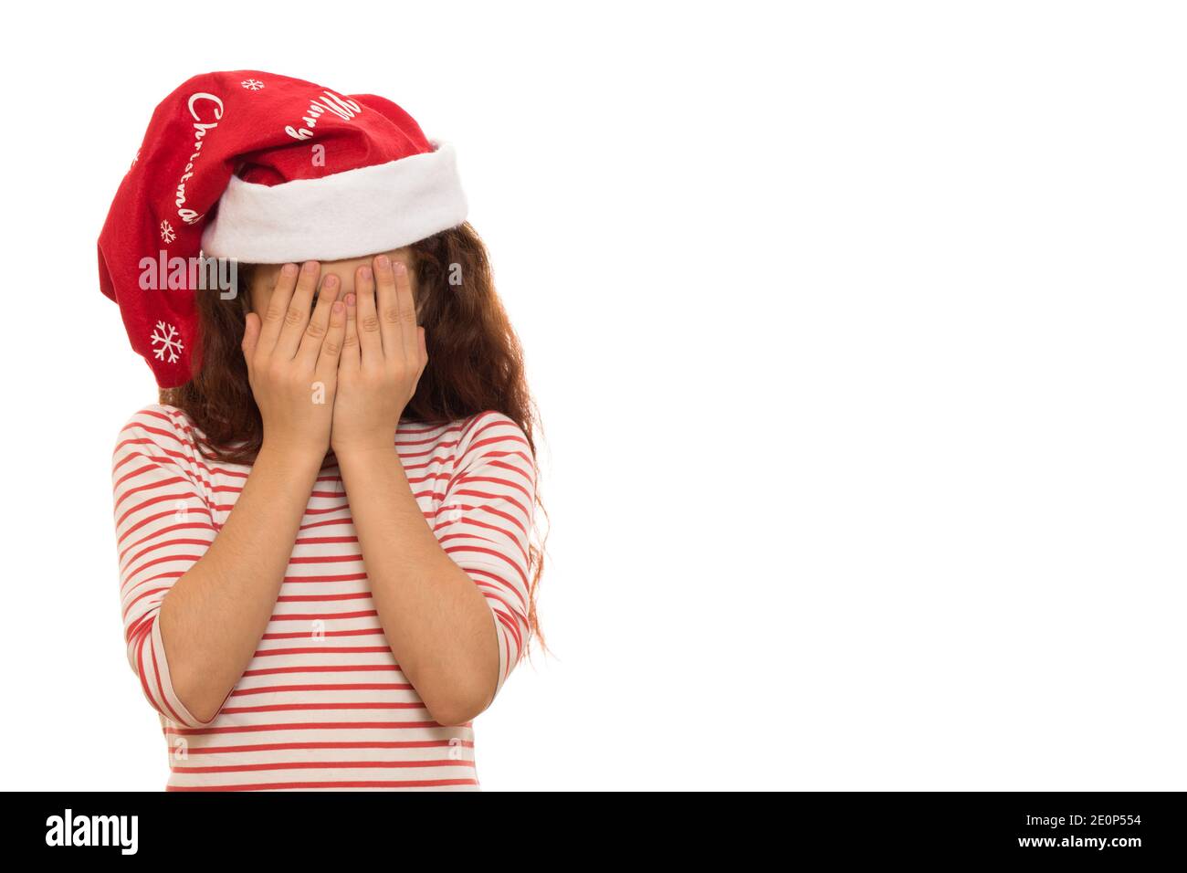 Studioaufnahme eines kleinen Mädchens in Santa Claus Weihnachten hut weinend versteckt ihr Gesicht in ihren Händen isoliert Copyspace Traurige Sadnes deprimierten Angst ängstlich Stockfoto