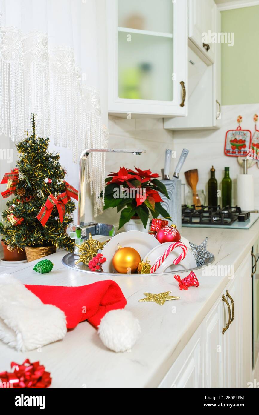 Weihnachtsspielzeug und ungewaschene Geschirr in der Küchenspüle Stockfoto