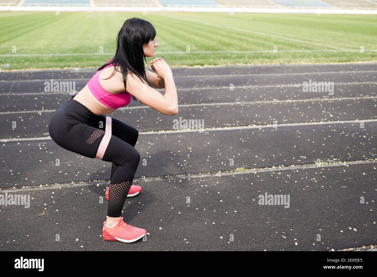 Immer in gutem Zustand. Moderne junge Frau in Sportbekleidung springen während der Ausübung im Freien. Fitness-Hintergrund mit Platz für Text. Stockfoto