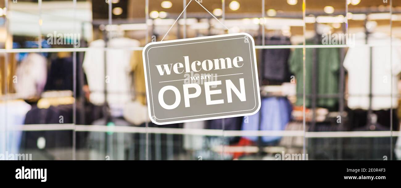 Öffnen Sie den Shop mit dem Nachrichtentext auf dem Fenster 'Willkommen, wir sind Open' - Bannerdesign Stockfoto