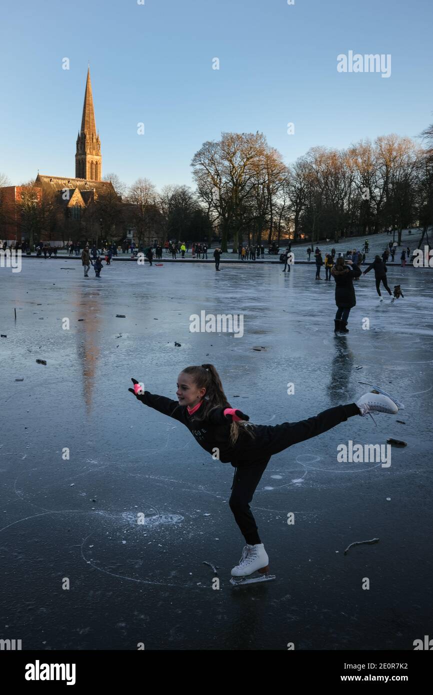 Glasgow, Großbritannien, 2. Januar 2021. Die Leute nutzen das kalte Wetter zum Schlittschuhlaufen und spazieren auf dem gefrorenen Bootsteich im Queen's Park, in der Südseite der Stadt. Die Polizei entfernte schließlich alle aus dem Eis, weil sie sich Sorgen um die Sicherheit gemacht hatte. Foto: Jeremy Sutton-Hibbert/ Alamy Live News Stockfoto