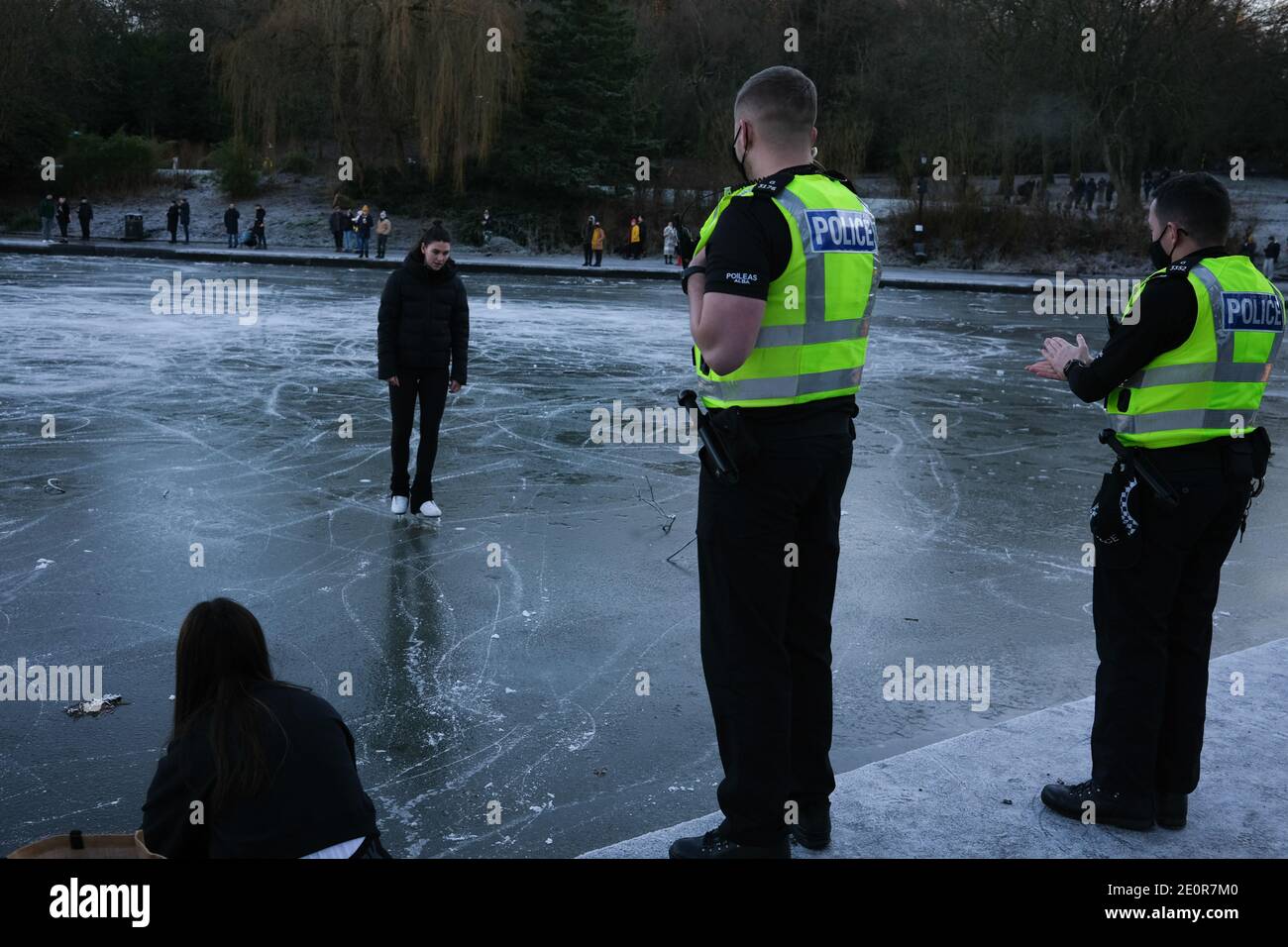 Glasgow, Großbritannien, 2. Januar 2021. Die Leute nutzen das kalte Wetter zum Schlittschuhlaufen und spazieren auf dem gefrorenen Bootsteich im Queen's Park, in der Südseite der Stadt. Die Polizei entfernte schließlich alle aus dem Eis, weil sie sich Sorgen um die Sicherheit gemacht hatte. Foto: Jeremy Sutton-Hibbert/ Alamy Live News Stockfoto